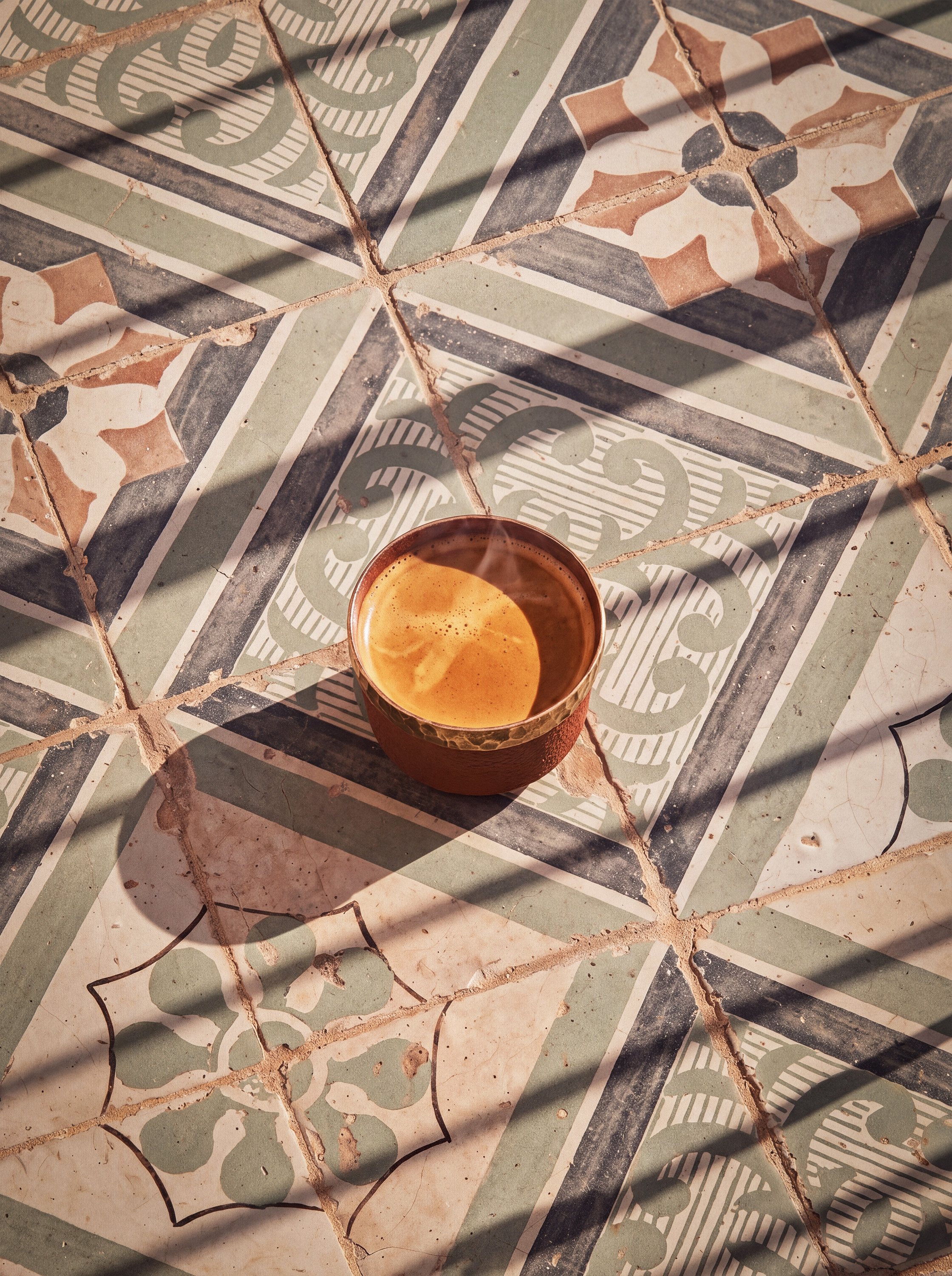 Overhead PEETAL on mosaic tiles, diagonal sunlight shadows